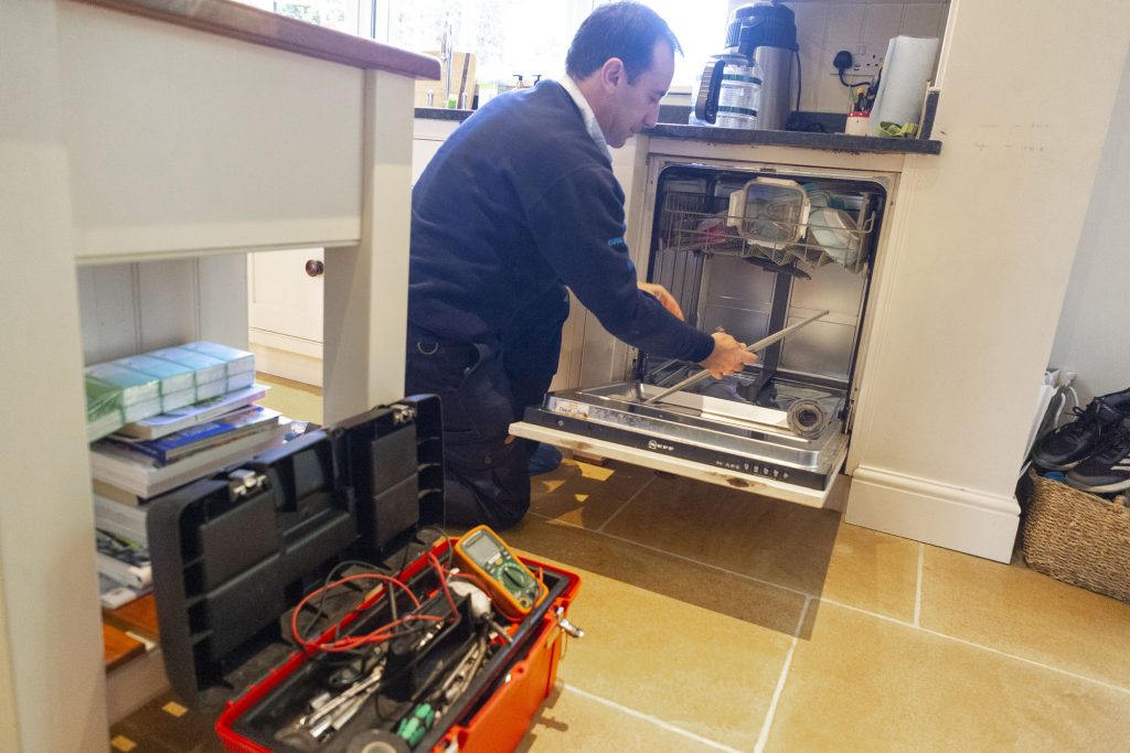 Domex engineer repairing dishwasher in Ilford