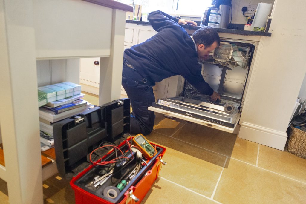 Domex engineer repairing dishwasher in Sutton