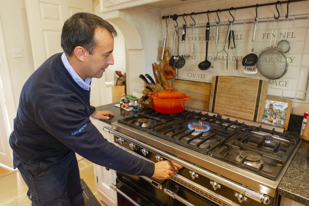 Domex Engineer repairing gas hob in kitchen in Ealing