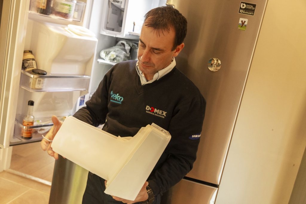 Domex Engineer inspecting fridge freezer leaking water - Domex Ltd